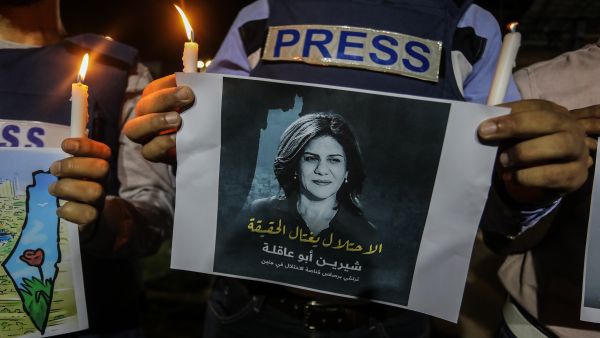 Palestinians take part in a candlelight vigil to condemn the killing of veteran Al Jazeera journalist Shireen Abu Aqleh, in Rafah, in the southern Gaza Strip, on May 11, 2022. Shutterstock image