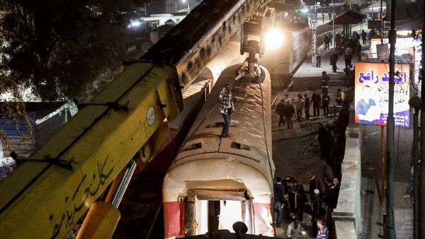 A crane is deployed to lift a derailed train at the scene of a railroad accident in the city of Qalyub in Qalyub province