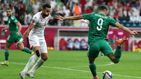 Algeria's forward Baghdad Bounedjah (R) attempts a shot as he is marked by Tunisia's midfielder Ghailene Chaalali during the FIFA Arab Cup 2021 final football match between Tunisia and Algeria at the Al-Bayt stadium in the Qatari city of Al-Khor on December 18, 2021. (Photo by DENOUR / AFP)