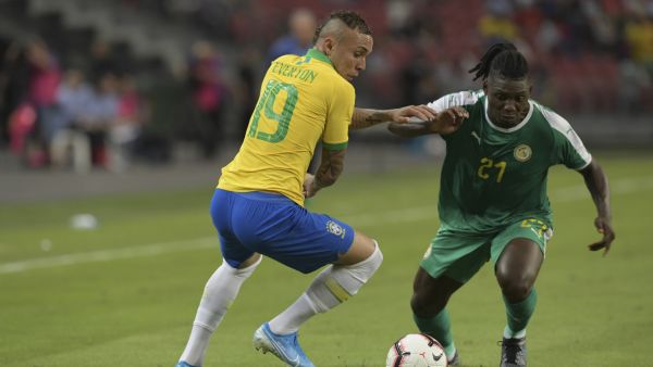 Senegal's Lamine Gassama (R) fights for the ball with Brazil's Everton (L) during the friendly international football match between Brazil and Senegal at the National Stadium in Singapore on October 10, 2019. / AFP / ROSLAN RAHMAN