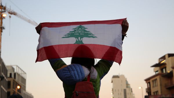 فتاة تحمل العلم اللبناني فوق رأسها