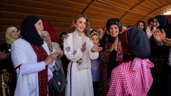 الملكة رانيا ترتدي زيا تراثيا أبيض اللون وسط مجموعة من النساء 