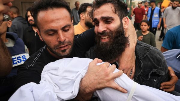 The father (R) of a young boy from the al-Aqad family, reacts as he holds the body of his child, killed an Israeli strike on Khan Yunis in the southern Gaza Strip, before his burial on October 29, 2023. The Israeli army has intensified its strikes against Hamas in the Gaza Strip despite calls for de-escalation, and ordered Palestinian civilians to leave for the south of the territory. (Photo by MAHMUD HAMS / AFP) Gaza