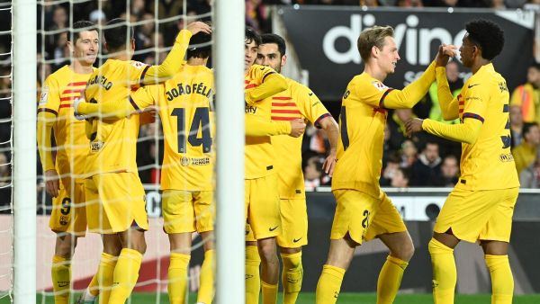 Barcelona's Portuguese forward #14 Joao Felix celebrates scoring the opening goal, with teammates, during the Spanish league football match between Valencia CF and FC Barcelona at the Mestalla stadium in Valencia on December 16, 2023. (Photo by JOSE JORDAN / AFP)