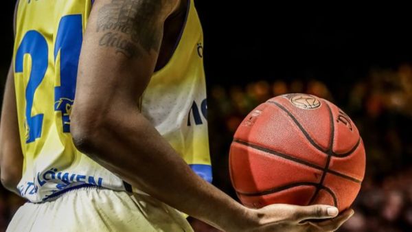 لاعب كرة سلة يحمل كرة سلة في يده لاعب كرة سلة يحمل كرة سلة في يده