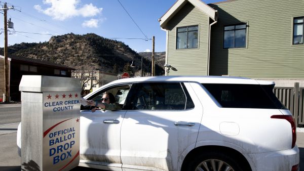 A voter drops off her ballot at the Clear Creek Public Health Building during the presidential primary in Idaho Springs, Colorado on Super Tuesday, March 5, 2024. Americans from 15 states and one territory vote simultaneously on "Super Tuesday," a campaign calendar milestone expected to leave Donald Trump a hair's breadth from securing the Republican Party's presidential nomination. (Photo by Jason Connolly / AFP) Idaho USA