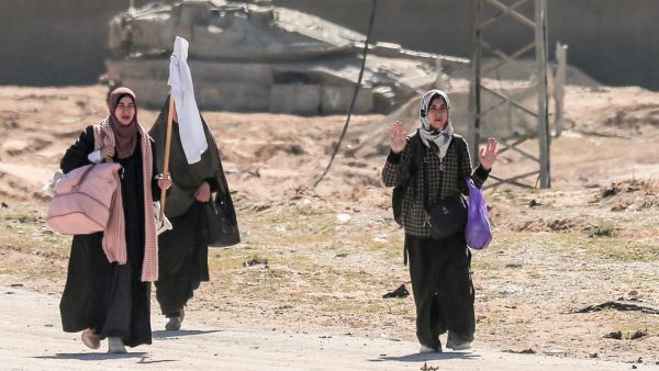 نساء يرفعن الراية البيضاء، وخلفهن دبابة للجيش الإسرائيلي في قطاع غزة