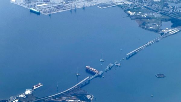 This aerial view shows the collapsed Francis Scott Key Bridge lying on top of the container ship Dali in Baltimore, Maryland, on March 31, 2024 (Photo by Daniel SLIM / AFP) Baltimore bridge