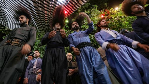 أشخاص بشعور طويلة ويرتدون أزياء موحدة، يؤدون ما يشبه الطقوس الدينية
