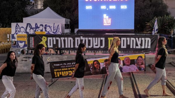 Women demonstrators dressed up as Israeli hostage Naama Levy, an army soldier abducted from the military base of Nahal Oz during the October 7, 2023 attacks by Palestinian militants from the Gaza Strip. (Photo by Jack GUEZ / AFP) Israeli hostage