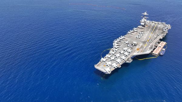 Aerial drone photo of USS Gerald R. Ford latest technology nuclear powered aircraft carrier anchored in deep blue open ocean sea (Shutterstock) aircraft carrier