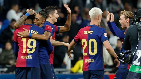 Barcelona players celebrate their victory at the end of the Spanish league football match between Real Madrid CF and FC Barcelona at the Santiago Bernabeu stadium in Madrid on October 26, 2024. (Photo by OSCAR DEL POZO / AFP)