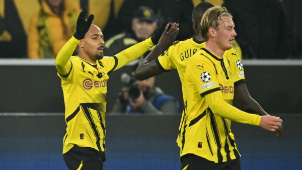 Dortmund's Dutch forward #21 Donyell Malen celebrates scoring the opening goal with his teammates Dortmund's Guinean forward #09 Serhou Guirassy and Dortmund's German midfielder #10 Julian Brandt during the UEFA Champions League football match BVB Borussia Dortmund vs SK Sturm Graz in Dortmund, western Germany on November 5, 2024. (Photo by INA FASSBENDER / AFP)
