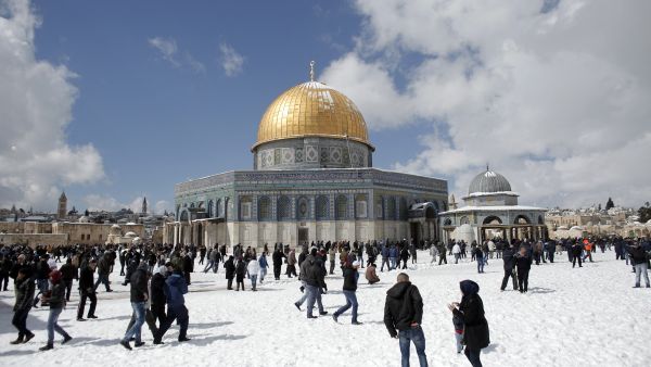 Palestinians play in the snow outside the Dome of the Rock mosque (top L) at the al-Aqsa mosque compound, Islam’s third holiest site, following a snow storm on February 20, 2015, in Jerusalem's old city. AFP Israeli settlers storm Al-Aqsa Mosque under police protection in mass morning raid