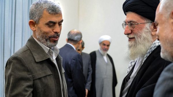A handout picture provided by the office of Iran's Supreme Leader Ayatollah Ali Khamenei on October 19, 2024, shows him (R) greeting slain Hams leader Yahya Sinwar in Tehran on February 12 2012.  (Photo by KHAMENEI.IR / AFP) A handout picture provided by the office