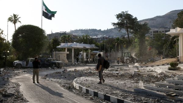 Syrian security forces and people walk inside the heavily damaged Syrian army and defence ministry headquarters complex in Damascus, following Israeli strikes on July 16, 2025. (Photo by Bakr ALkasem / AFP) Israeli strike