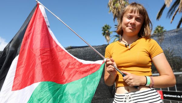 Swedish climate activist Greta Thunberg poses with a Palestinian flag as a flotilla carrying humanitarian aid and activists prepare to leave for Gaza, in Barcelona on August 30, 2025. A flotilla carrying humanitarian aid and activists, including Swedish climate campaigner Greta Thunberg, is set to depart Barcelona on August 31 to try to "break the illegal siege of Gaza," organizers said. (Photo by LLUIS GENE / AFP) Greta Thunberg