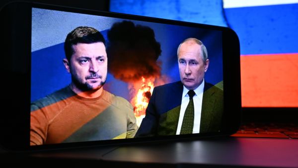 رئيس أوكرانيا فولوديمير زيلينسكي على شاشة الهاتف الذكي ورئيس روسيا فلاديمير بوتين.