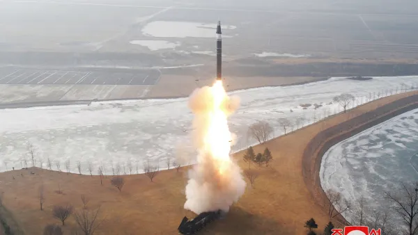 Missile accelerates in sky with bright flame from rocket engine nozzle