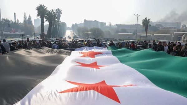 حشد من السوريين يحملون علم سوريا 