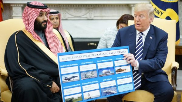 U.S. President Donald Trump (R) holds a defence sales chart with Saudi Arabia's Crown Prince Mohammed bin Salman in the Oval Office of the White House on Mar. 20, 2018 in Washington, DC. 
(MANDEL NGAN / AFP)