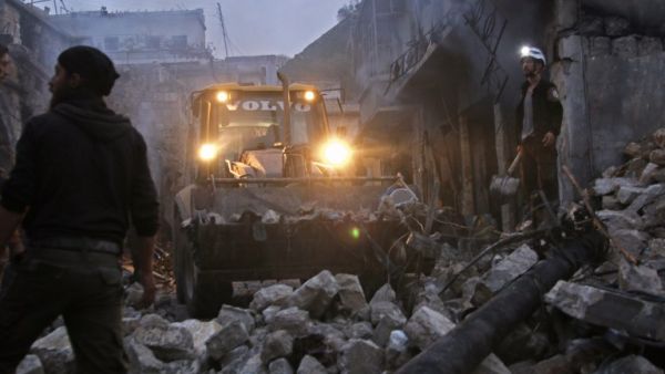 Members of the Syrian civil defence use a bulldozer to clear rubble as they search for survivors in the aftermath of an air strike in the rebel-held town of Harem in the northwestern Idlib province on Mar. 22, 2018. 
(Aaref WATAD / AFP)