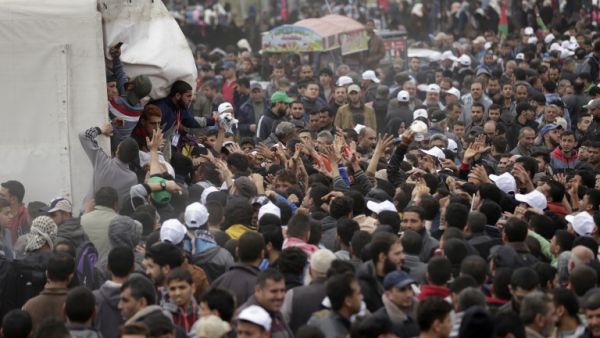 Palestinians gather to receive lunch packages after Friday prayers during a tent city protest near the border with Israel east of Gaza City to commemorate Land Day on Mar. 30, 2018. Land Day marks the killing of six Arab Israelis during 1976 demonstrations against Israeli confiscations of Arab land.
(MAHMUD HAMS / AFP)