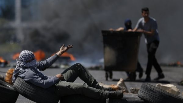 Palestinian men burn tyres during a protest in the West Bank city of Ramallah on Apr. 6, 2018. Clashes erupted on the Gaza-Israel border Friday, AFP journalists said, a week after similar demonstrations led to violence in which Israeli force killed 19 Palestinians, the bloodiest day since a 2014 war. Palestinians burned tyres and threw stones at Israeli soldiers over the border fence, who responded with tear gas and live fire, the correspondents said. (ABBAS MOMANI / AFP) Palestinian men burn tyres during a protest in the West Bank city of Ramallah on Apr. 6, 2018. Clashes erupted on the Gaza-Israel border Friday, AFP journalists said, a week after similar demonstrations led to violence in which Israeli force killed 19 Palestinians, the bloodiest day since a 2014 war. Palestinians burned tyres and threw stones at Israeli soldiers over the border fence, who responded with tear gas and live fire, the correspondents said. (ABBAS MOMANI / AFP)