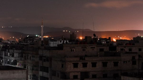 A picture taken early on Apr. 21, 2018 shows explosions appearing in the skyline of a southern district of the Syrian capital Damascus, during regime strikes targeting the Islamic State group in the Palestinian camp of Yarmouk, and neighbouring districts. 
(Rami al SAYED / AFP)
