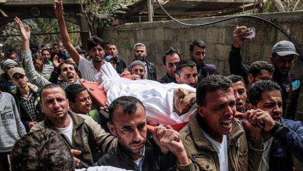 Mourners carry the body of 29-year-old Saadi Abu Taha who was killed during clashes along the Israel-Gaza border/ AFP