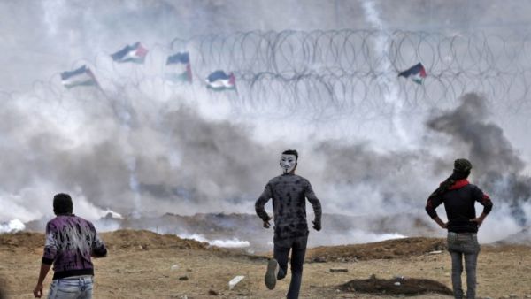 Palestinian protesters demonstrate near the fence on the Israel-Gaza border (AFP/File Photo)	