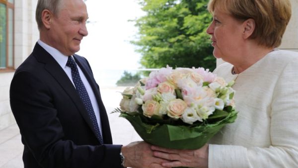 Russian President Vladimir Putin (L) welcomes German Chancellor Angela Merkel during their meeting in Sochi on May 18, 2018. (Mikhail KLIMENTYEV / SPUTNIK / AFP)