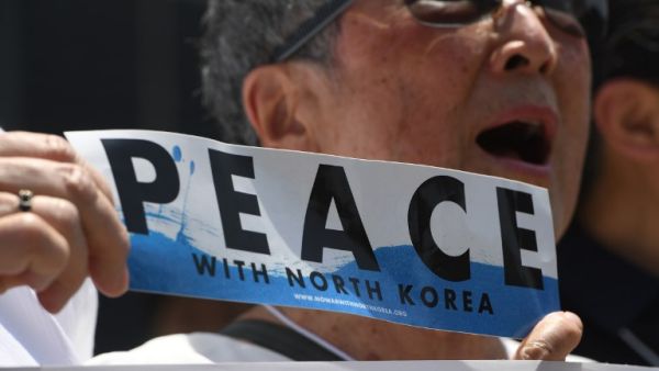 A peace activist holds a "Peace with North Korea" banner in a rally against President Donald Trump near the US Embassy in Seoul, May 25, 2018. North Korea stated it was still willing to talk to the United States after Trump cancelled a summit between the two countries, a decision that has thrown the Korean peninsula into uncertainty. (Jung Yeon-je / AFP)