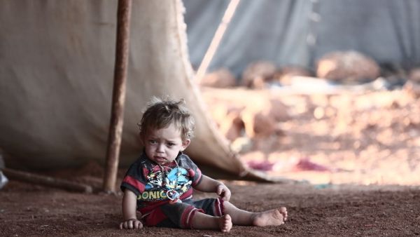 A child sits in front of a tent at a camp for the displaced from the rebel-held Syrian province of Idlib, at the village of al-Ghadfa, southeast of the province on September 2, 2018. (Nazeer AL-KHATIB / AFP)