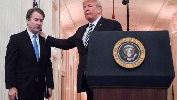 US President Donald Trump (R) pats Associate Justice of the US Supreme Court Brett Kavanaugh (L)  (AFP)