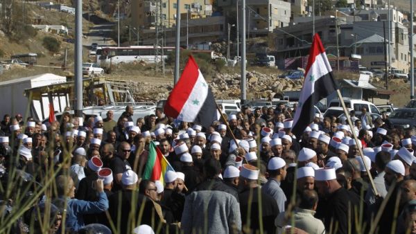 Druze men protest against municipal elections in front of a polling centre in the village of Majdal Shams in the Israeli-annexed Golan Heights on October 30, 2018 (AFP)