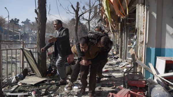 Afghan volunteers carry a body at the scene of a car bomb exploded in front of the old Ministry of Interior building in Kabul on January 27, 2018. (WAKIL KOHSAR / AFP)