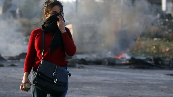 A Palestinian demonstrator covers her face during clashes with Israeli troops in Ramallah. (AFP)