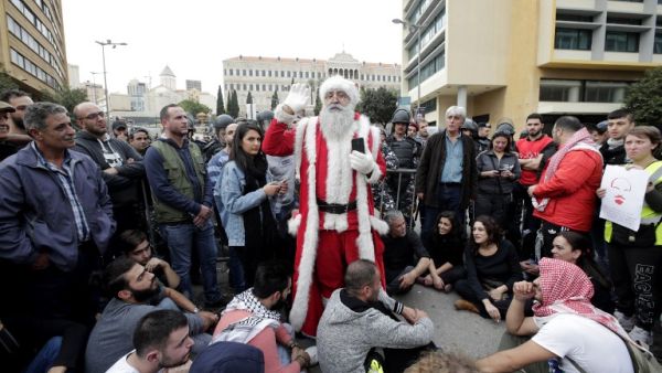 A Lebanese demonstrator, dressed as Santa Clause, delivers a speech during a demonstration against the country's political and economic situation on December 16, 2018, in the capital Beirut. (AFP)