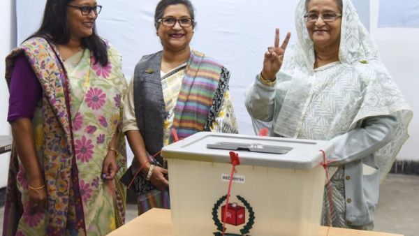 Bangladeshi Prime Minister Sheikh Hasina (R) flashes the victory symbol after casting her vote, as her daughter Saima Wazed Hossain (1st L) and her sister Sheikh Rehana (2nd L). (AFP)