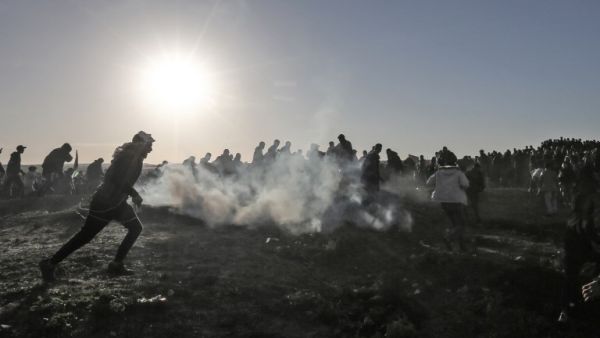 Palestinian protesters run through tear gas fumes during clashes with Israeli forces following a demonstration along the border with Israel east of Gaza City on January 11, 2019. (MAHMUD HAMS / AFP)
