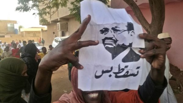 A Sudanese protester carries a portrait of President Omar al-Bashir with Arabic writing that reads "down and that is all" during an anti-government demonstration east of the capital Khartoum on February 8, 2019. (AFP)