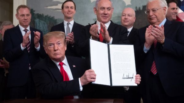 US President Donald Trump holds up a signed Proclamation on the Golan Heights alongside Israeli Prime Minister Benjamin Netanyahu in the Diplomatic Reception Room at the White House in Washington (AFP)