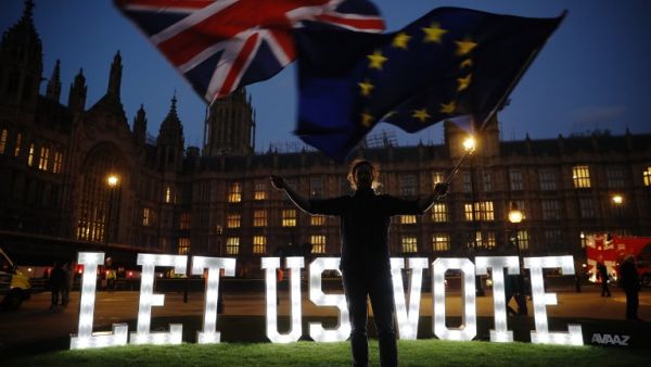 An anti-Brexit activist waves the Union and EU flags near the Houses of Parliament in central London on March 27, 2019. (Tolga AKMEN / AFP)