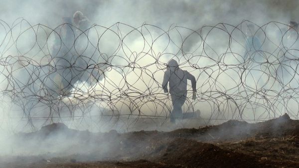 Palestinian protester running away from the border fence, as Palestinians demonstrate to mark the first anniversary of the "March of Return" protests. (Jack GUEZ / AFP)