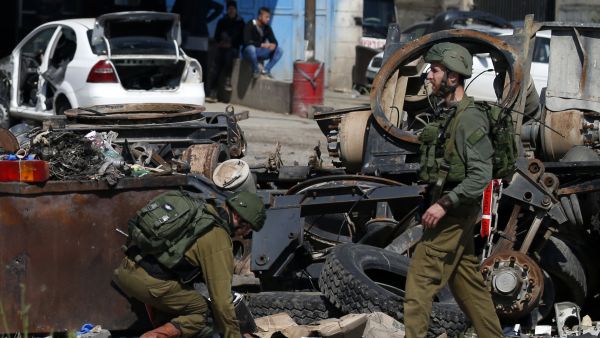 Israeli soldiers inspect the site where a Palestinian man was killed after he reported tried to stab an Israeli driver at a junction south of Nablus in the occupied West Bank on April 3, 2019. (JAAFAR ASHTIYEH / AFP)