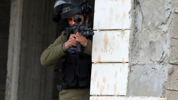 A member of the Israeli security forces aims fire during clashes with Palestinian protestors in the village of Qabatiya, near the West Bank town of Jenin, on February 6, 2016. (AFP/Jaafar Ashtiyeh)