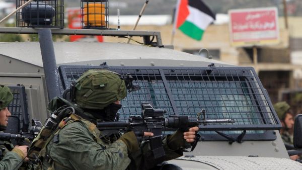 This file photo taken on February 6, 2016 shows an Israeli soldier aiming fire during clashes with Palestinian youths in the village of Qabatiyah, near the West Bank town of Jenin. (AFP/Jaafar Ashtiyeh)