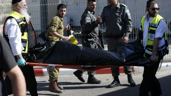 Ultra-Orthodox Jewish Zaka volunteers carry away on a stretcher the body of a Palestinian assailant who was shot dead following a reported attempt to stab Israeli border police, at a checkpoint near the Israeli settlement of Har Homa, between Jerusalem and Bethlehem in the occupied West Bank, on February 14, 2016. (AFP/Ahmad Gharabli)