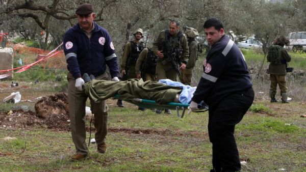 Members of the Palestinian Red Crescent carry the body of a Palestinian man who tried to stab an Israeli soldier before being shot dead, at the Bitot Junction south of Nablus in the northern occupied West Bank,on February 21, 2016. (AFP/Jaafar Ishtiyeh)